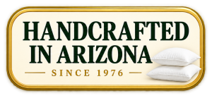 Gold-framed badge reading 'HANDCRAFTED IN ARIZONA' with 'SINCE 1976' and two white pillows on the right